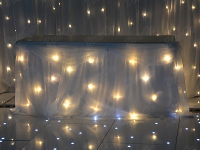 TourGo white chiffon table backdrop with white warm lights for wedding