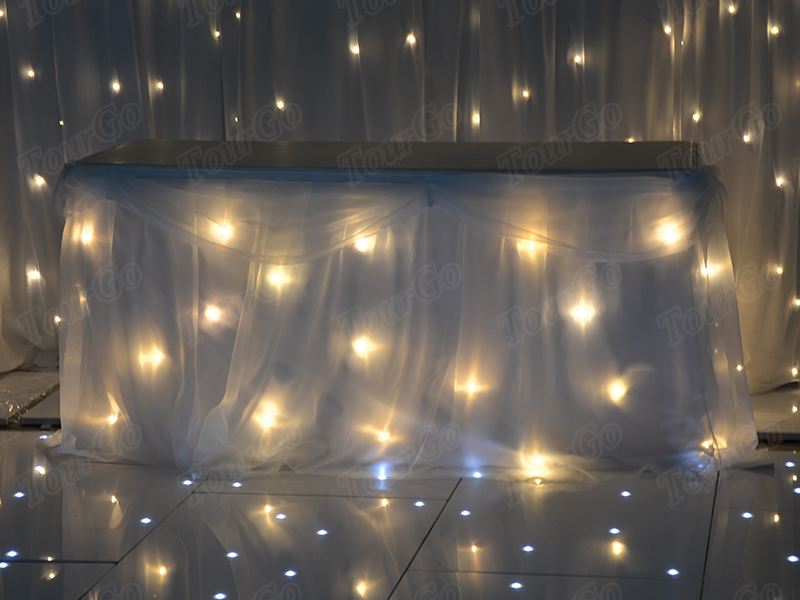 TourGo white chiffon table backdrop with white warm lights for wedding
