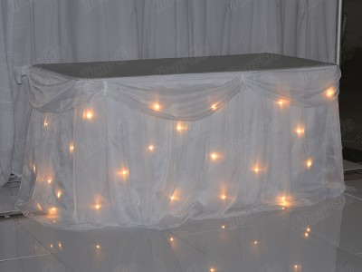 TourGo white chiffon table backdrop with white warm lights for wedding